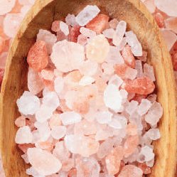 Himalayan pink salt crystals on a wooden spoon